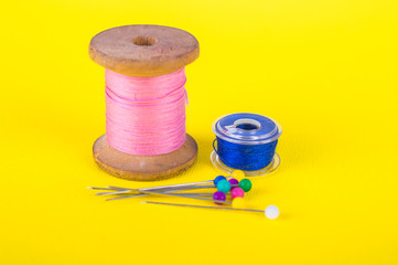 Different threads and pins. On a yellow background.