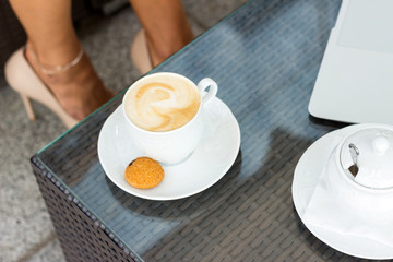 woman drinking coffe in the cafe onteh street
