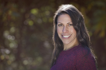 Portrait Of A Mature Woman Smiling At the Camera At The Park