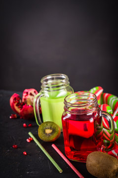 Smoothies of kiwi juice pomegranate juice in the jar with a handle on a dark background