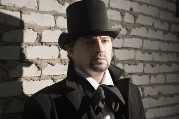 Victorian man in the black coat, top hat and in a tie