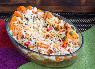 Vegetarian dish of orange pumkin, vegetables, herbs and cheese
