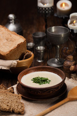 Creamy mushroom soup with herbs on  background of authentic dish