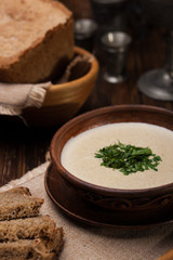 Creamy mushroom soup with herbs on  background of authentic dish