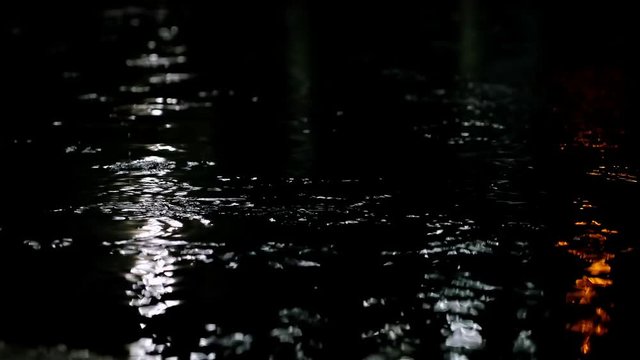 Closeup shot of heavy rain on road at night