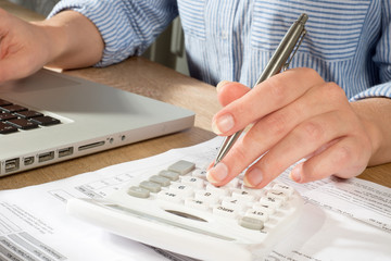 Person in Shirt at Table Accounting with Laptop and Calculator