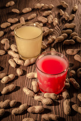 Banana and strawberry juice in a glass on a wooden background with nuts