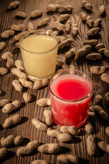 Banana and strawberry juice in a glass on a wooden background with nuts