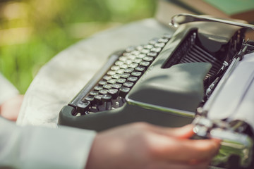 Young man writing a letter on old typewriter