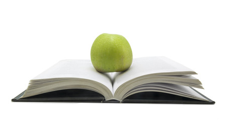 Open book with apple on it isolated on white background