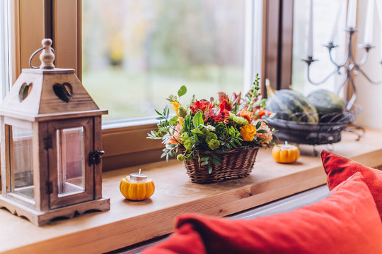 Window sill decorated with pumpkins and a flowerpot