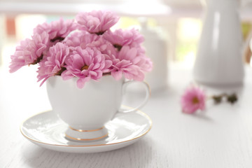 Bouquet of beautiful flowers in a cup on a  table