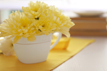 Bouquet of beautiful flowers in a cup on a  yellow napkin