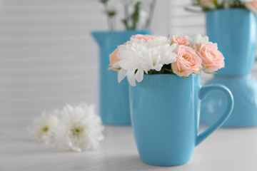Bouquet of beautiful flowers in a cup on a  table