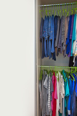 Jeans and pants hung on hangers in the wardrobe. Hangers in a ro