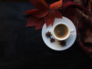 Кофе и красные осенние листья на чёрном фоне. Красный...