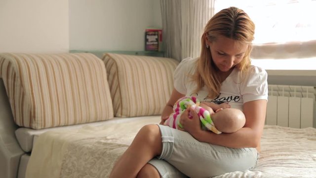 mom breastfeeding her little daughter
