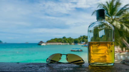 Beach party. Holiday fun concept. Bottle of rum and sunglasses w