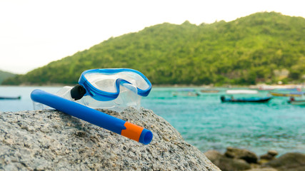 Snorkeling equipment: snorkel and diving google on the stone. Tr