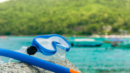 Snorkeling equipment: snorkel and diving google on the stone. Tr