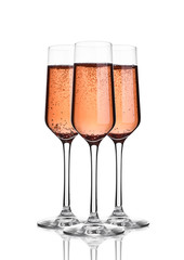 Glass of pink rose champagne with bubbles on white