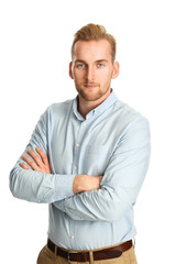 A handsome man in his 20s standing against a white background, wearing a blue shirt tucked in to...