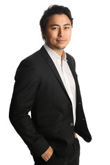 An attractive businessman wearing a black blazer with a white shirt, standing against a white background looking at camera. Smile on his face.