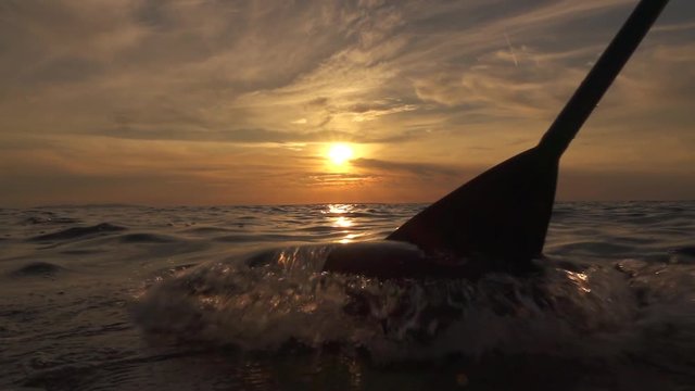 SLOW MOTION: Sea splashing into camera when pushing paddle blade through water