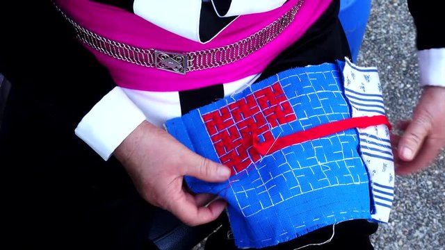 Close-up female hand of Hmong hilltribe embroider pattern colored thread.