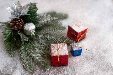 New Year Christmas. Spruce branches covered with snow. On the snow lie gifts in boxes. Good New Year spirit.