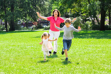 Grandmother And Grandchildren Running In Park