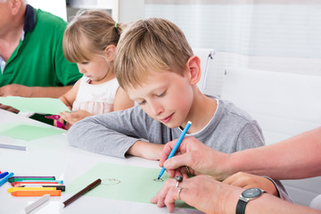 Multi Generation Family Drawing On Colorful Paper