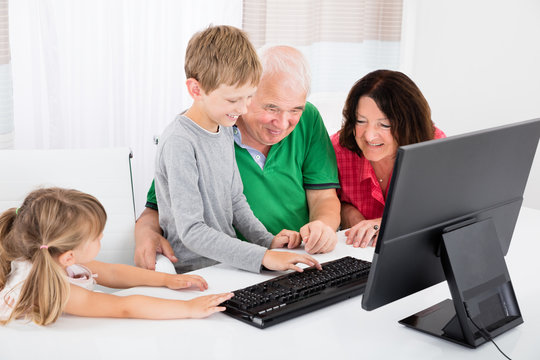 Multi Generation Family Using Desktop Together At Home