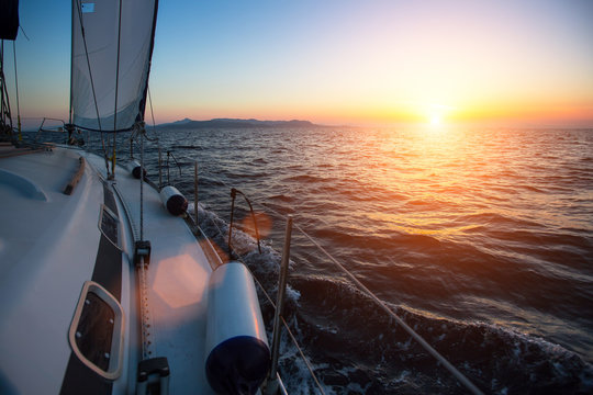 Fototapeta Yacht sailing against sunset. Luxury boat. Vacation and Travel Concept.