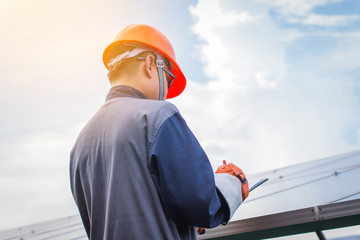 an engineer working on checking equipment in solar power plant; checking array box or inverter