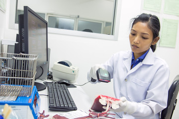 Doctor scanning data from the blood bags - Powered by Adobe