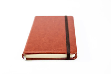 Small brown notebook isolated in white background.