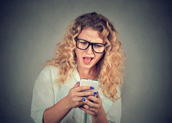 stressed woman holding cellphone mad at stressful texts and calls