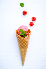Raspberry ice cream in cone with fresh raspberry and peppermint