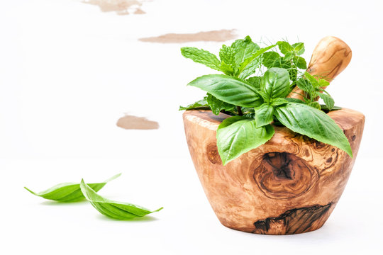 Alternative medicine fresh herbs in the wooden mortar . Food ing