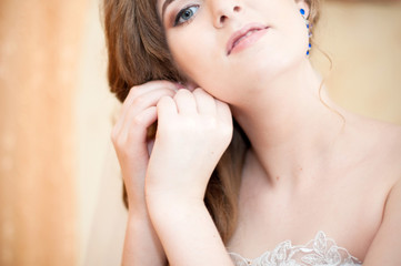 Obraz na płótnie Canvas молодая невеста одевает серьги