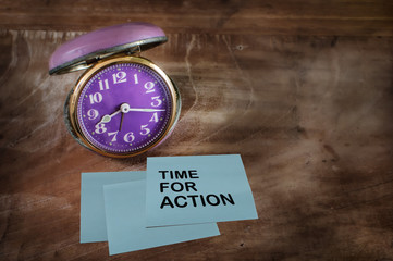 Word of Time for action on sticky note with alarm clock, time management concept