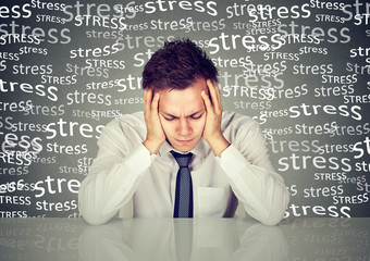 Desperate young business man leaning on a desk