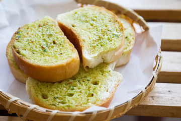 Garlic grilled bread in wooden basket close up.