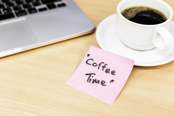 coffee time in pink pos it and laptop keyboard, on wood background