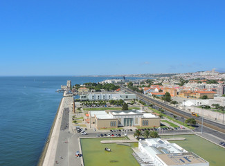 Fototapeta na wymiar Lisbon, Portugal. Landscape from the Monument to the Discoveries (named Padrao dos Descobrimentos) to the Belem tower, Tagus river, 25 de Abril Bridge, Atlantic ocean and Monastery named Jeronimos