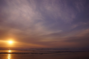 Dramatic ocean sunset with clouds and blue sky