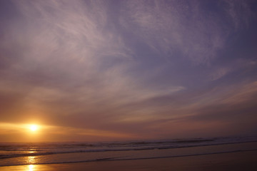 Dramatic ocean sunset with clouds and blue sky