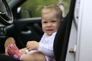 Small cute baby in a car in a warm day