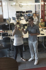 young couple at modern office interior writing notes on stickers